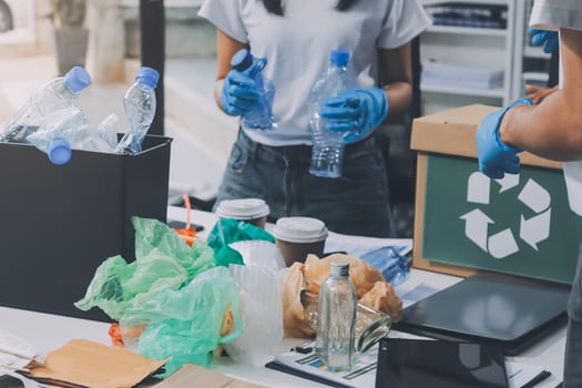 Two people working on a desk with recycling items photo