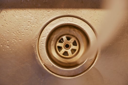 Close-up of water draining from a kitchen sink in early afternoon photo
