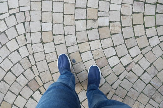 Walking on a cobblestone path in casual footwear photo