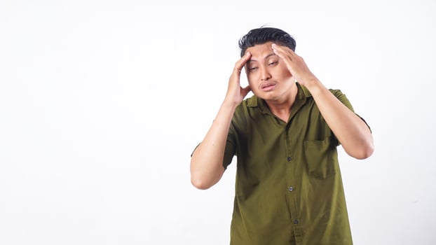 Asian man showing headache symptoms by touching his head isolated on white background photo