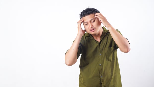 Stressed Asian man suffering from strong headache touching head isolated on white background photo