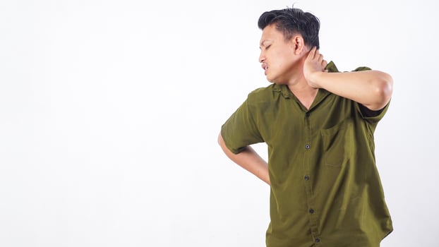 Asian man in distress, clutching his neck due to severe pain isolated on white background photo