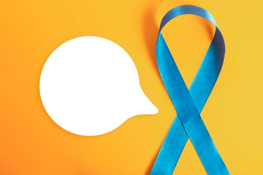 Blue awareness ribbon with blank speech bubble on yellow background photo
