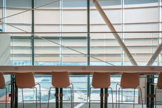 Row of chairs with wooden counter table on window glass in airport photo