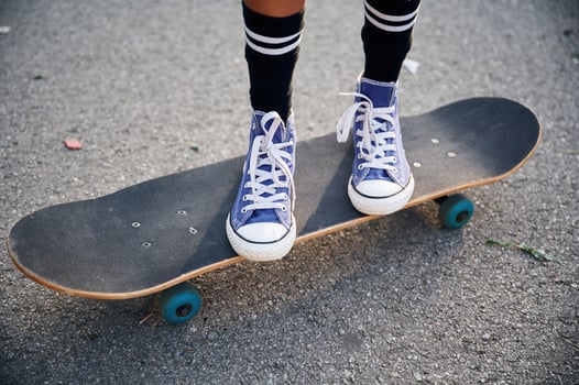 Close up view of skateboard riding by a young girl photo