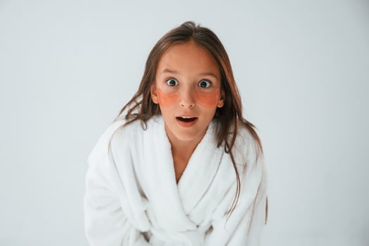 Positive and surprised, facial expression. With eye patches. Conception of beauty. Young girl is in the studio photo