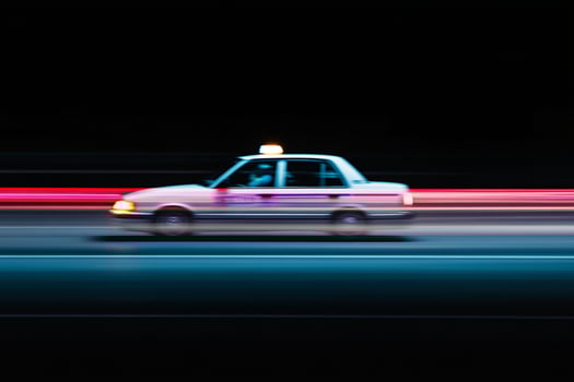 A taxi cab driving down the road at night photo