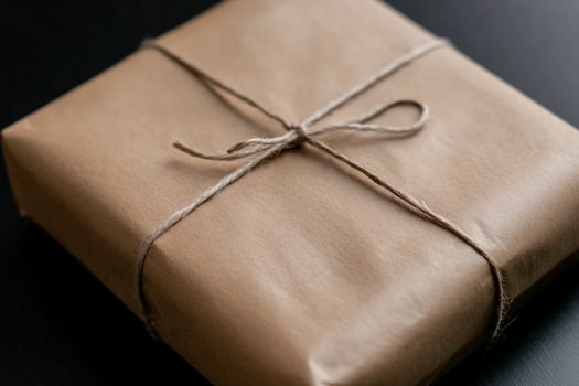 A brown wrapped gift box on a black table photo