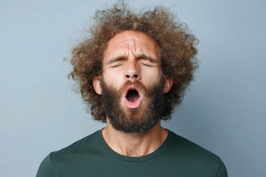 A man with curly hair and beard is yawning photo