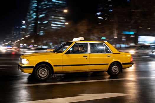 A taxi cab driving down the street at night photo