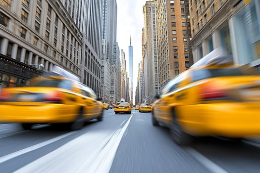 A group of yellow cabs driving down a busy street photo