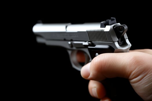 A person holding a gun on a black background photo