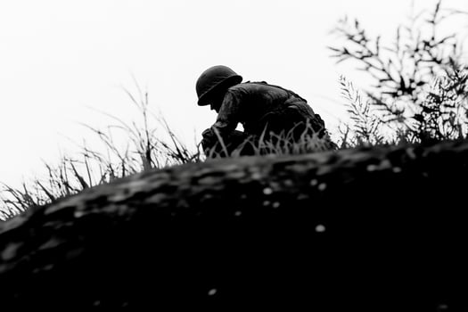 A soldier is sitting on top of a hill photo