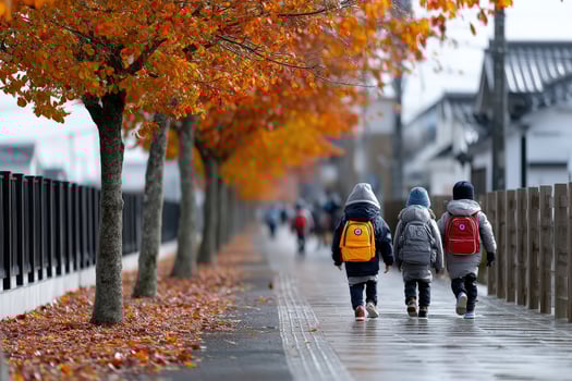 Children walking along a tree-lined street with autumn leaves in a vibrant neighborhood photo