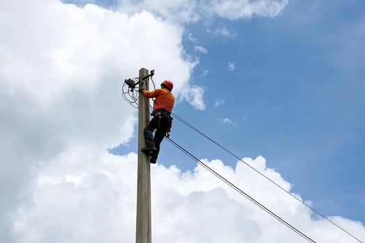 A man is working on a power pole photo