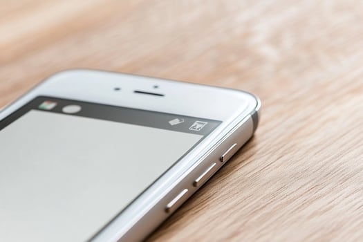 An iphone is sitting on a wooden table photo