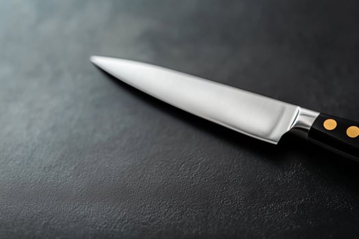 A knife on a black surface with a black background photo