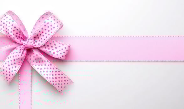 A pink ribbon with a bow tied to it photo