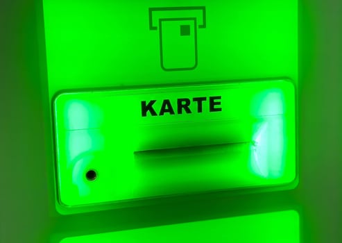 Neon green atm card slot with illuminated card symbol for bank transactions photo