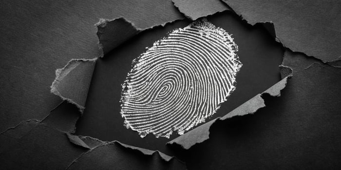 Fingerprint reveal business concept, identity or security in a torn black paper background for data protection or evidence photo