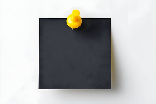 Yellow push pin holding blank black note on white background for reminders or messages at office or home workspace photo