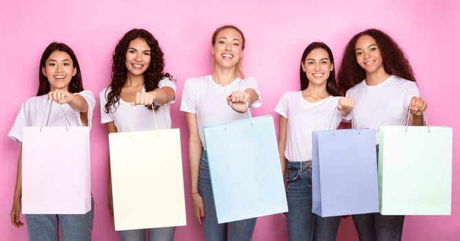Shopping And Shopaholism. Cheerful Diverse Ladies Showing Colorful Shopper Bags Smiling To Camera Posing Over Pink Studio Background. Buyers Advertising Sales And Discounts Concept. Panorama photo