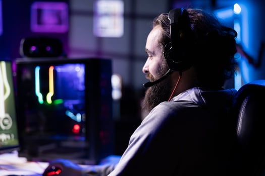 Player reaching final mission in coop FPS videogame, battling flying robots with online friends, using headphones. Gamer wearing headset playing game, fighting final boss helped by teammates photo