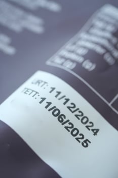 Expiration dates on product label visible on a gray background photo