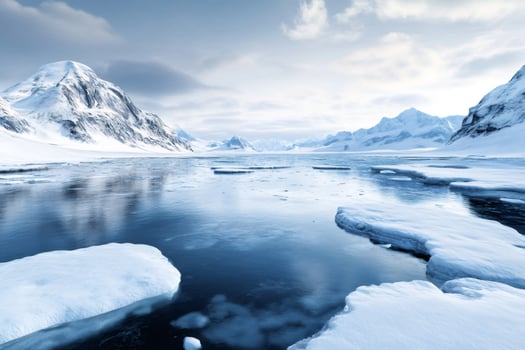 Ice floes floating on arctic ocean with snowy mountains reflecting in water photo