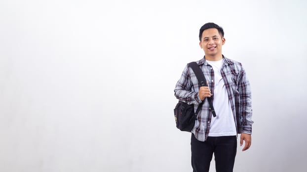 Handsome young Asian male college student with a backpack isolated on white background photo