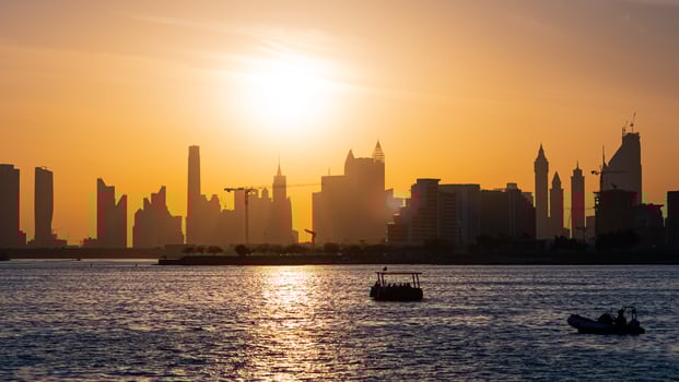 The sun sets over the city skyline of dubai photo