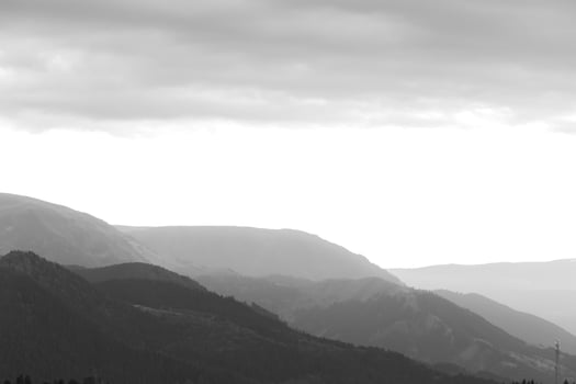 Black and white landscape of the mountain range with partly cloudy sky photo