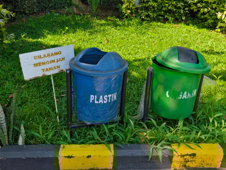 Blue and Green Trash Bins with No Stepping Sign in a Park Area photo