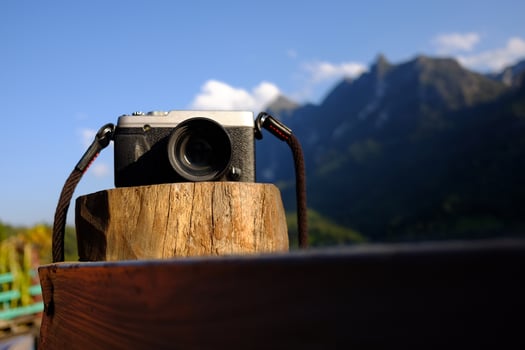 Vintage mirrorless camera on wooden pole of terrace with valley Doi Luang Chiang Dao mountain view, Chiang Mai Province of Thailand photo