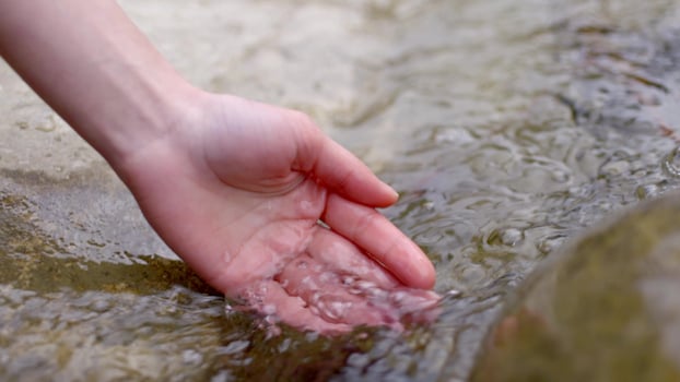 Collecting water from river into hand palm photo
