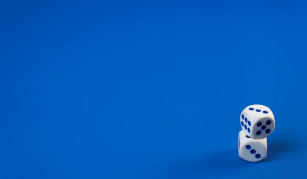 White dice stacked on top of each other against a vibrant blue background photo