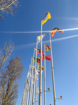 Vibrant international flags wave against a clear blue sky. A perfect image for concepts of global unity, diversity, travel, or international events. photo