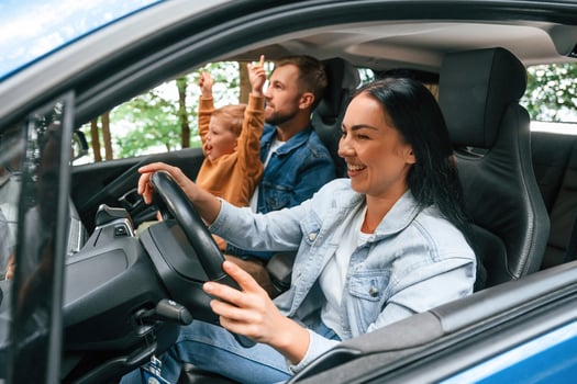 On a trip. Family ,of ,ather, mother and little son are sitting in the modern car photo