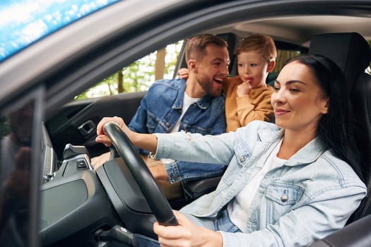 Cheerful ,people, driving. Family of father, mother and little son are sitting in the modern car photo