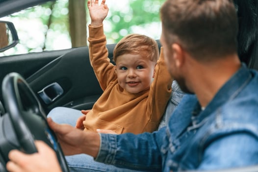 Fathe,r with ,his little son are sitting in the car photo