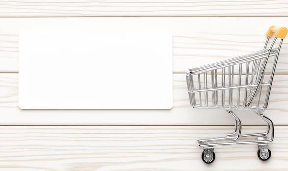 A shopping cart with a blank card on a wooden table photo