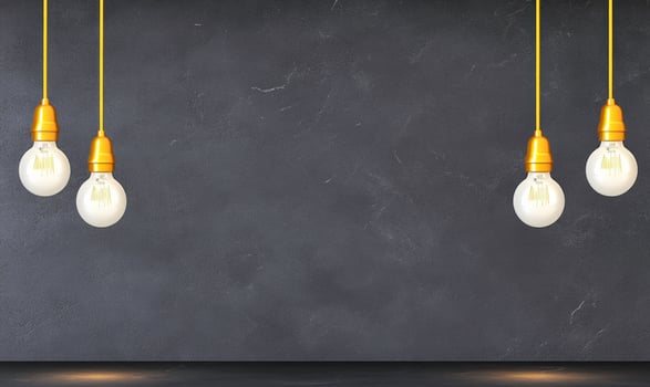 Three light bulbs hanging from a black wall photo