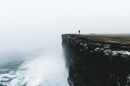 A person standing on the edge of a cliff photo
