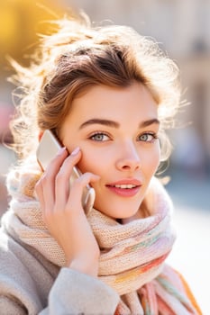 Young woman wearing a scarf talking on phone in autumn city photo