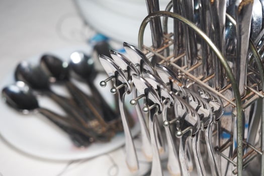Silver utensils neatly arranged in a kitchen setting for dining photo