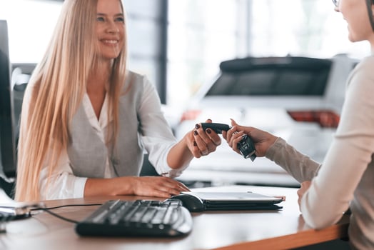 Sitting, by, the, table. Female manager is helping woman customer in the car dealership salon photo