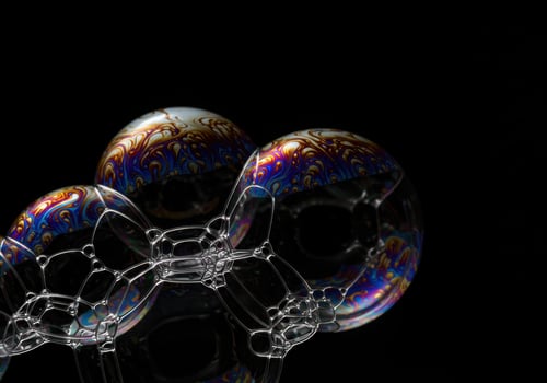 Vibrant soap bubbles exhibit intricate patterns in a close-up shot against a black background. photo