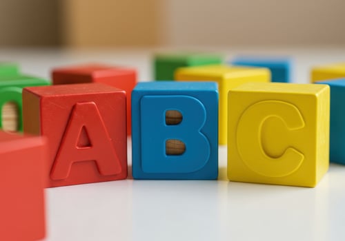 The vibrant wooden abc blocks are arranged on a white surface, perfect for learning. photo