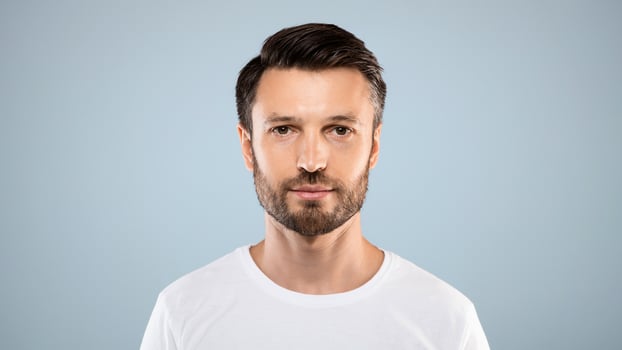 Portrait of handsome bearded man over grey studio background, empty space. Middle-aged bearded man posing for male magazine or blog, youth, healthy lifestyle and male cosmetology concept photo