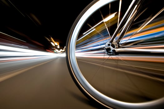 A bicycle wheel is seen in motion on the road photo